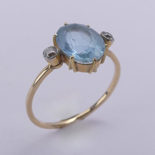 173 - An aquamarine and diamond Ring, the central oval facetted aquamarine approx. 10.8mm long, claw set w... 