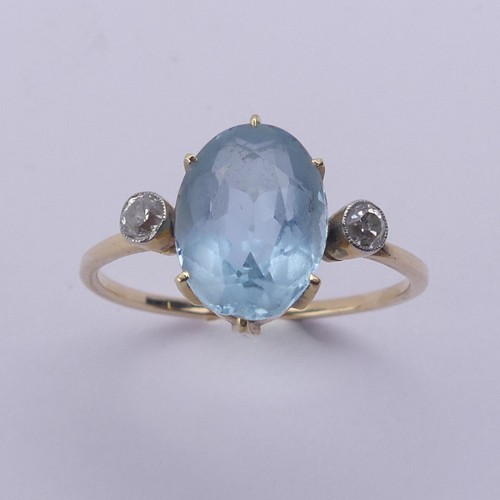 173 - An aquamarine and diamond Ring, the central oval facetted aquamarine approx. 10.8mm long, claw set w... 