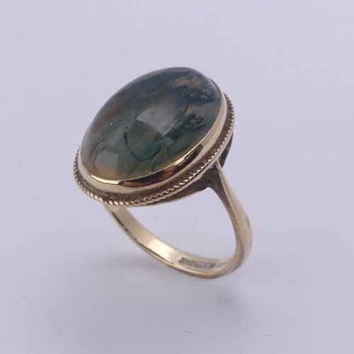 174 - A moss agate Ring, the oval cabochon stone approx. 17mm long, in a 9ct yellow gold mount, Size O, 4g... 