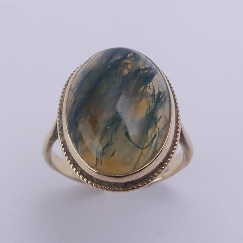 174 - A moss agate Ring, the oval cabochon stone approx. 17mm long, in a 9ct yellow gold mount, Size O, 4g... 