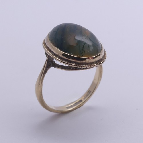 174 - A moss agate Ring, the oval cabochon stone approx. 17mm long, in a 9ct yellow gold mount, Size O, 4g... 