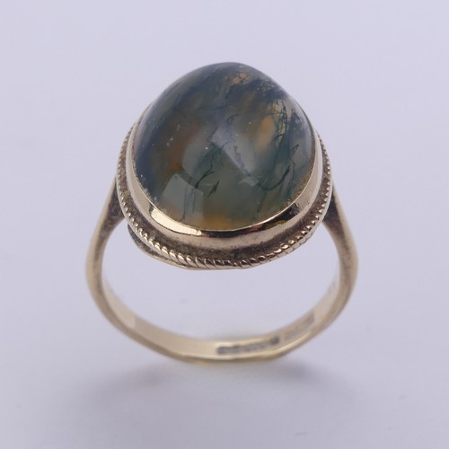 174 - A moss agate Ring, the oval cabochon stone approx. 17mm long, in a 9ct yellow gold mount, Size O, 4g... 