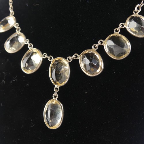 257 - A vintage citrine Necklace, the seven oval facetted stone with one further suspended below collet se... 