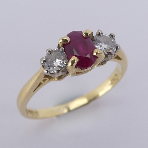 190 - A three stone ruby and diamond Ring, the central oval facetted ruby 5.9mm with a small circular diam... 