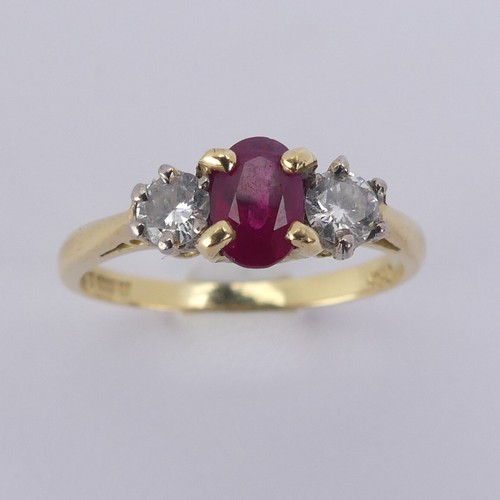 190 - A three stone ruby and diamond Ring, the central oval facetted ruby 5.9mm with a small circular diam... 