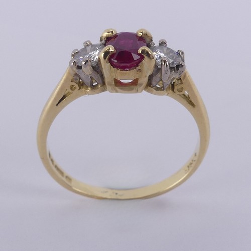 190 - A three stone ruby and diamond Ring, the central oval facetted ruby 5.9mm with a small circular diam... 