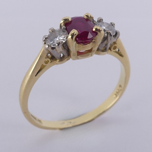 190 - A three stone ruby and diamond Ring, the central oval facetted ruby 5.9mm with a small circular diam... 