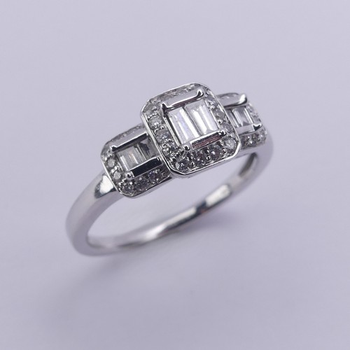 193 - A contemporary graduated triple cluster diamond Ring, each cluster with two baguette diamonds to the... 