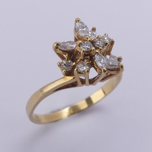 194 - A diamond cluster Ring, the navette and brilliant cut stones claw set in an abstract foliate design,... 