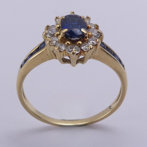 196 - A sapphire and diamond cluster Ring, the central oval facetted sapphire approx. 5.9mm long, within a... 