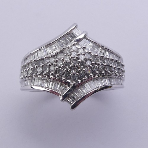 200 - A contemporary diamond Dress Ring, the flared front with central pavé set cluster within a ba... 