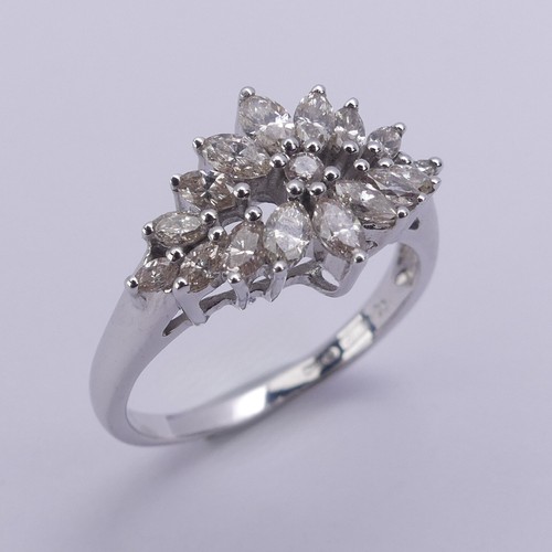 204 - A foliate diamond dress Ring, with graduated navette shaped stones around a small central brilliant ... 