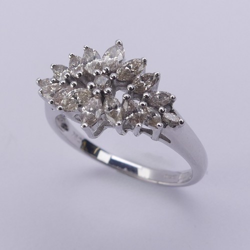 204 - A foliate diamond dress Ring, with graduated navette shaped stones around a small central brilliant ... 