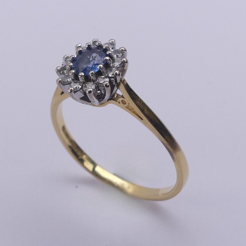 216 - A sapphire and diamond cluster Ring, the oval cluster 9.5mm long, all mounted in 18ct yellow and whi... 