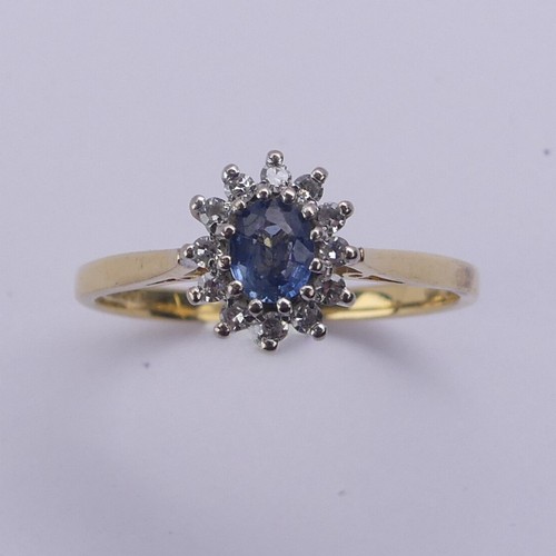 216 - A sapphire and diamond cluster Ring, the oval cluster 9.5mm long, all mounted in 18ct yellow and whi... 