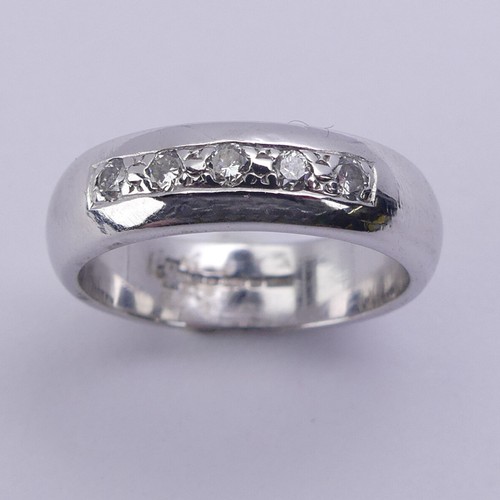 219 - A 9ct white gold Band, the front channel set with five small brilliant cut diamonds, 4.8mm wide, Siz... 