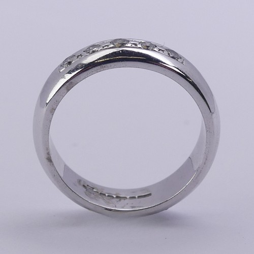 219 - A 9ct white gold Band, the front channel set with five small brilliant cut diamonds, 4.8mm wide, Siz... 