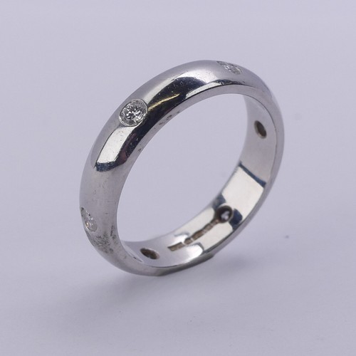 220 - A platinum Band, set with six small circular cut diamonds, Size J, 3.9mm wide, 5.6g.... 