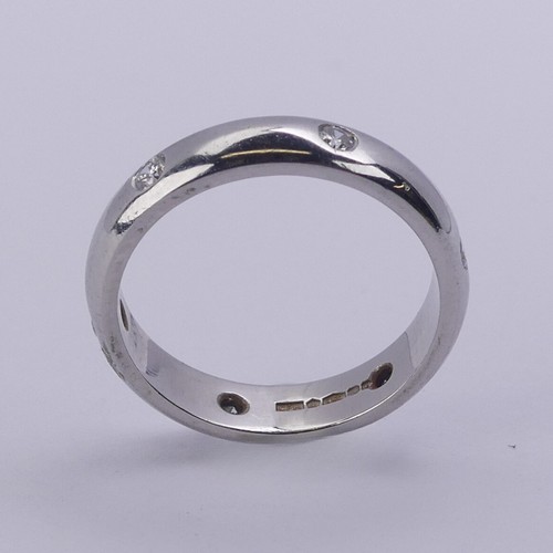 220 - A platinum Band, set with six small circular cut diamonds, Size J, 3.9mm wide, 5.6g.... 