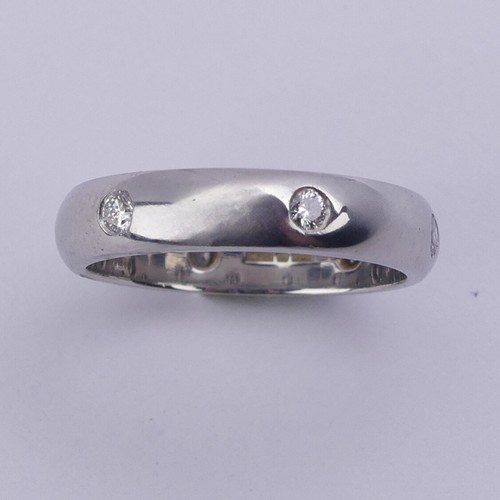 220 - A platinum Band, set with six small circular cut diamonds, Size J, 3.9mm wide, 5.6g.... 