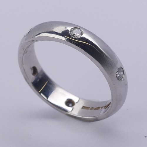 220 - A platinum Band, set with six small circular cut diamonds, Size J, 3.9mm wide, 5.6g.... 