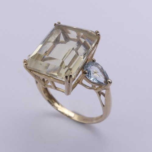 221 - A QVC citrine Dress Ring, the emerald cut stone 15.8mm x 11.9mm with a pear shaped pale blue stone o... 