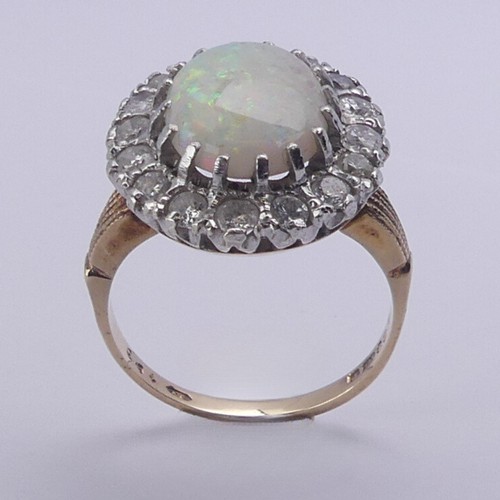 226 - An opal and diamond cluster Ring, the central oval opal 12mm long surrounded by sixteen circular dia... 