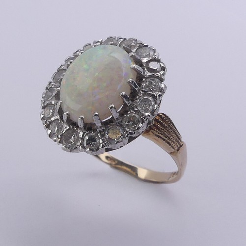 226 - An opal and diamond cluster Ring, the central oval opal 12mm long surrounded by sixteen circular dia... 