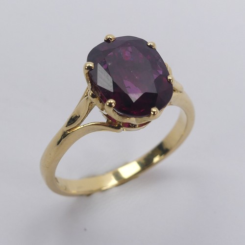 227 - A single stone ruby Ring, the striking oval cushion shaped stone with purple hues, six claw set in 1... 