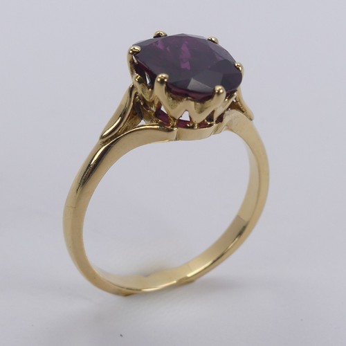 227 - A single stone ruby Ring, the striking oval cushion shaped stone with purple hues, six claw set in 1... 