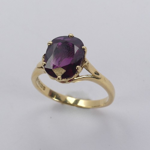 227 - A single stone ruby Ring, the striking oval cushion shaped stone with purple hues, six claw set in 1... 