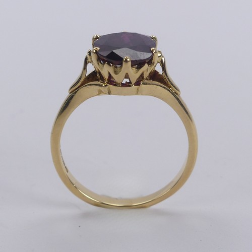 227 - A single stone ruby Ring, the striking oval cushion shaped stone with purple hues, six claw set in 1... 