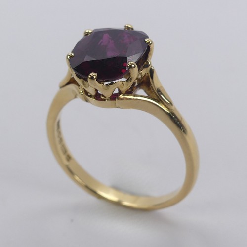 227 - A single stone ruby Ring, the striking oval cushion shaped stone with purple hues, six claw set in 1... 