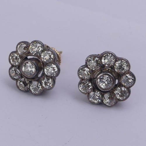 282 - A pair of diamond flowerhead cluster Earrings, the old cut stones millegrain set in white metal and ... 