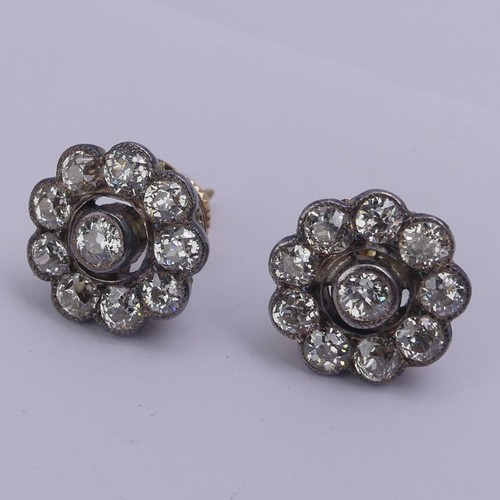 282 - A pair of diamond flowerhead cluster Earrings, the old cut stones millegrain set in white metal and ... 