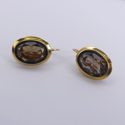 289 - A pair of oval facetted smoky quartz Earrings, the stones approx. 13.5mm long, collet set in unmarke... 