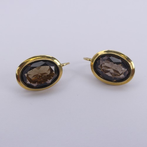 289 - A pair of oval facetted smoky quartz Earrings, the stones approx. 13.5mm long, collet set in unmarke... 