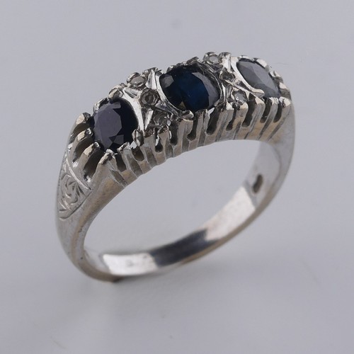 176 - A three stone sapphire Ring, the cushion shaped facetted stones with three diamond points vertically... 