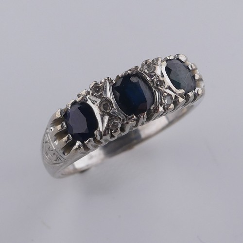 176 - A three stone sapphire Ring, the cushion shaped facetted stones with three diamond points vertically... 