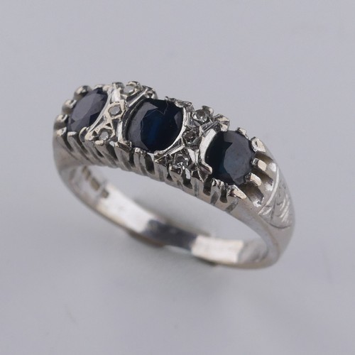 176 - A three stone sapphire Ring, the cushion shaped facetted stones with three diamond points vertically... 