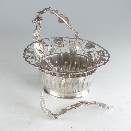 121 - A Continental silver swing handled Basket, of oval form, the rim pierced with fruit and vine decorat... 