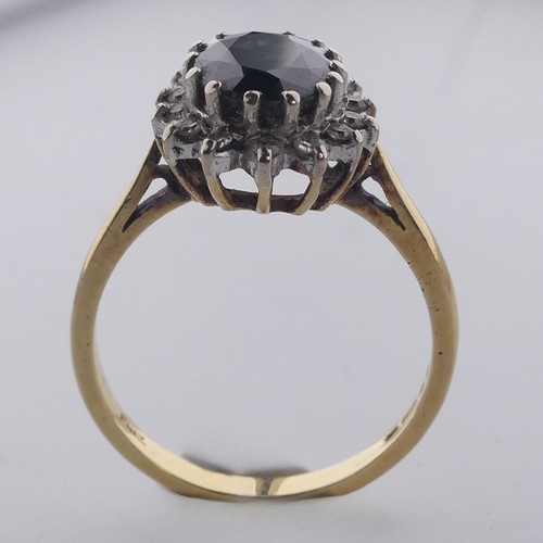 187 - A sapphire and diamond cluster Ring, the oval facetted sapphire approx. 10mm long, claw set within a... 