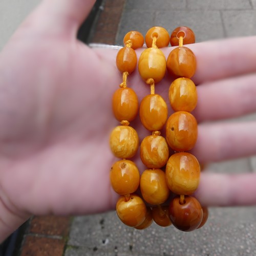 300 - A graduated amber bead Necklace, the largest 16mm long, on replacement string and paste clasp, toget... 