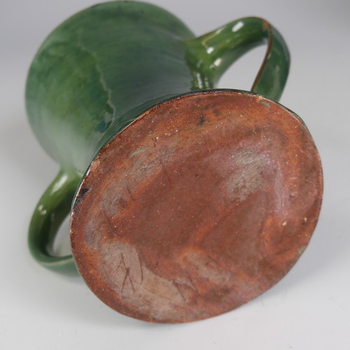 32 - Edward Sadler; a Devonia Art Pottery Character Jug, in deep green glaze, incised signature to base, ... 