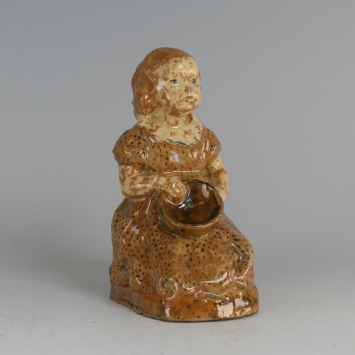 27 - A North Devon pottery figure of a Young Girl, possibly by Edwin Beer Fishley, modelled seated clutch... 