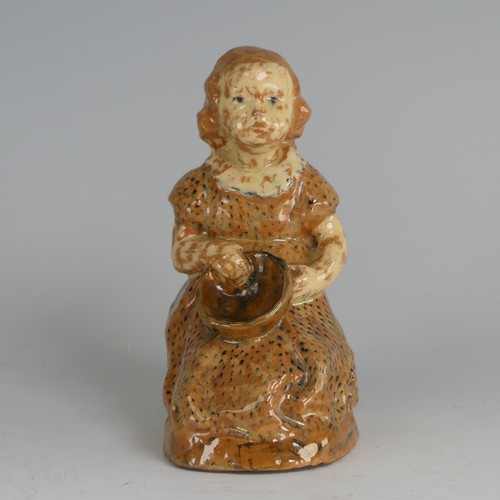 27 - A North Devon pottery figure of a Young Girl, possibly by Edwin Beer Fishley, modelled seated clutch... 