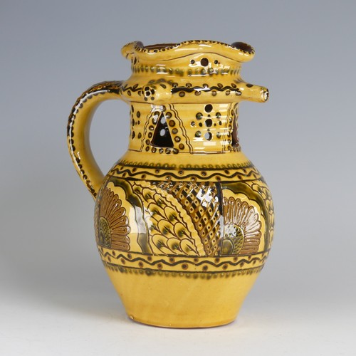 64 - Nick Juniper (20th century) a Bideford pottery Puzzle Jug, decorated with slipware with sunflowers a... 