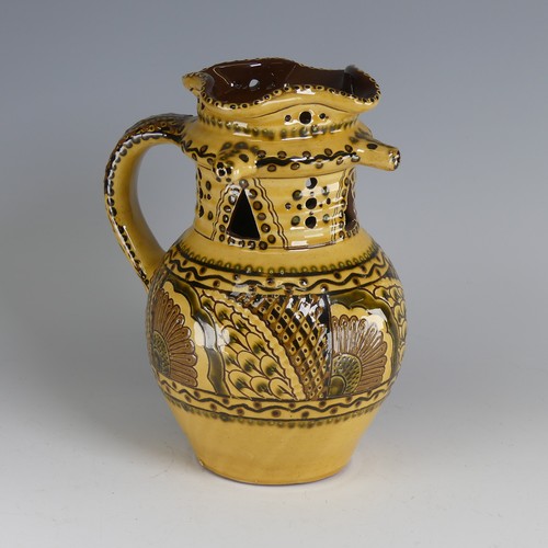 64 - Nick Juniper (20th century) a Bideford pottery Puzzle Jug, decorated with slipware with sunflowers a... 