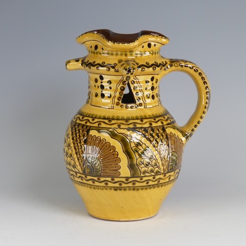 64 - Nick Juniper (20th century) a Bideford pottery Puzzle Jug, decorated with slipware with sunflowers a... 