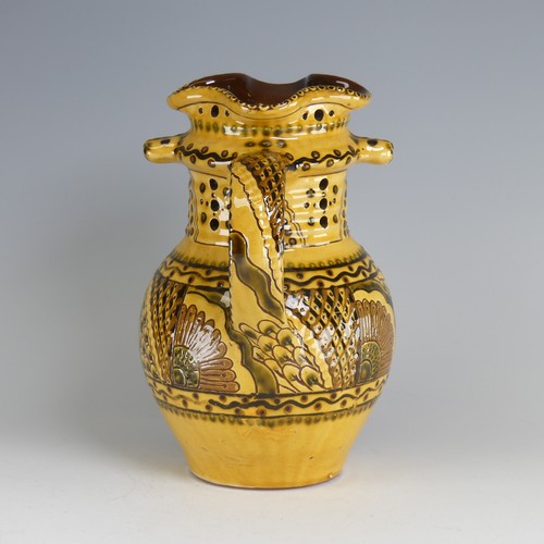 64 - Nick Juniper (20th century) a Bideford pottery Puzzle Jug, decorated with slipware with sunflowers a... 